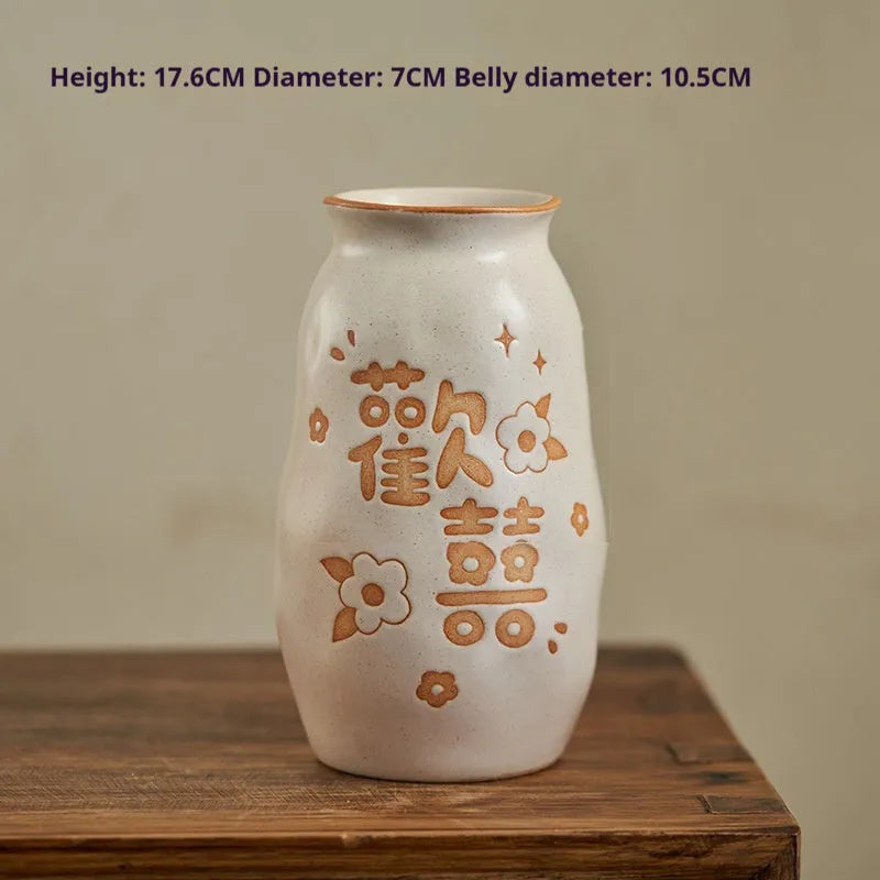 Chinese hand-painted ceramic vase with carved design on wooden desktop