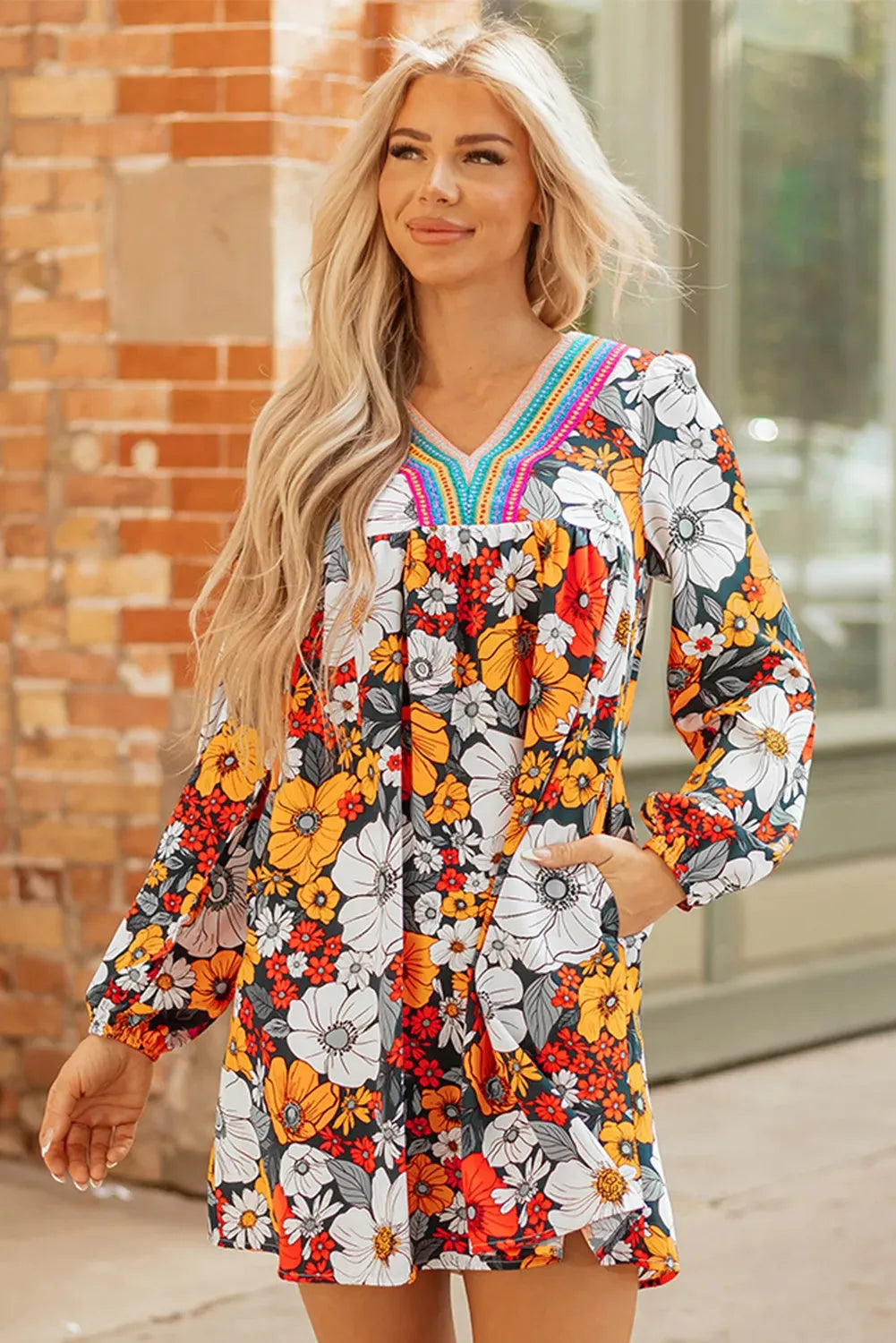 Orange floral print mini dress with striped lace detailing, V-neck, and long sleeves.