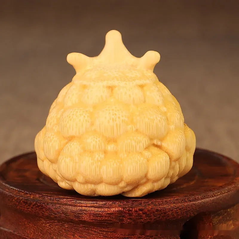 Close-up of a hand-carved bamboo Crown Princess toad ornament with live eye detailing.