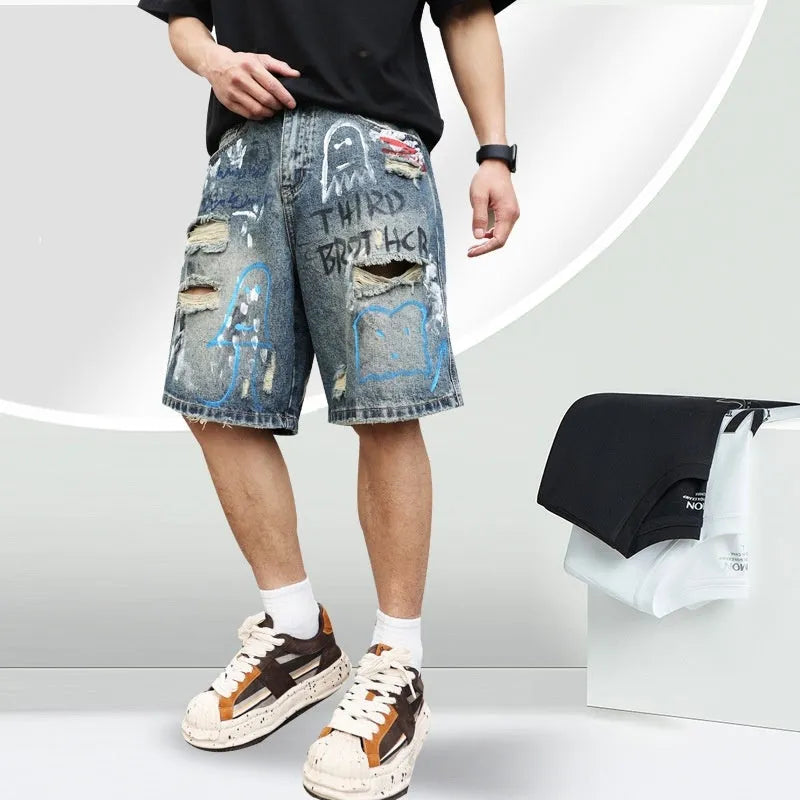 Blue mens denim shorts with ripped knees and graffiti design, straight leg fit.