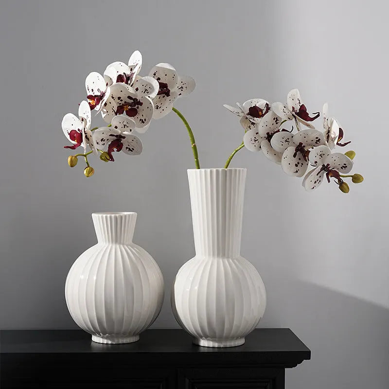 White ceramic ball-shaped vase with striped American country design on a table.