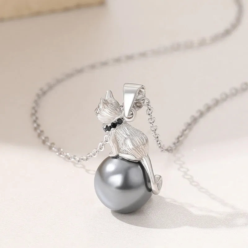 Close-up of a sterling silver cat pendant on a clavicle chain, showing detailed feline design and bright electroplated finish.