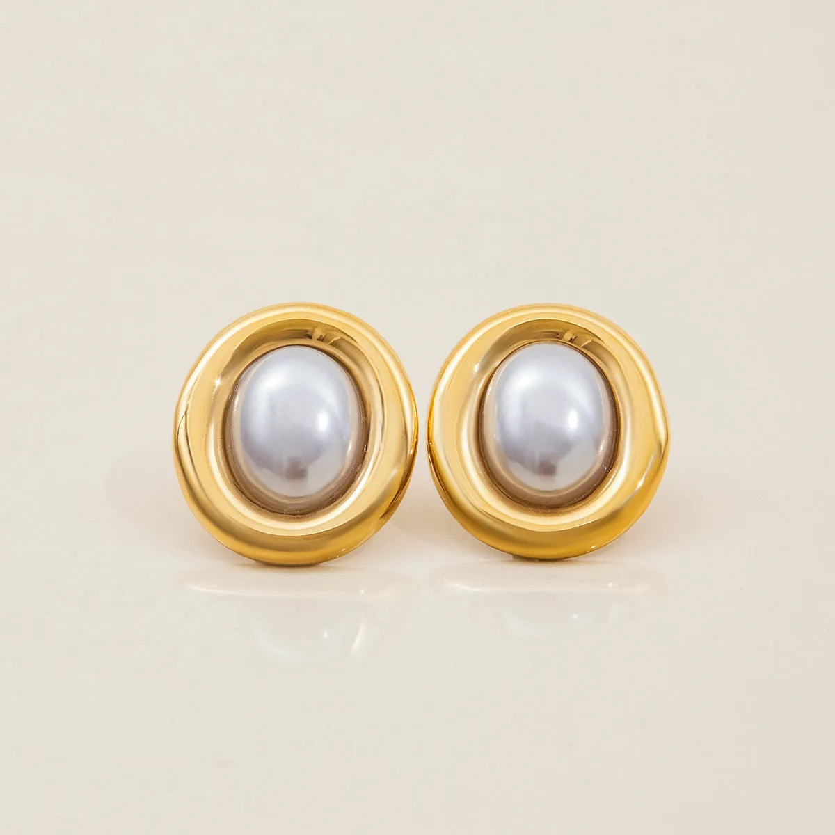 A pair of women's stainless steel stud earrings with a vintage-style pearl and electroplated finish.