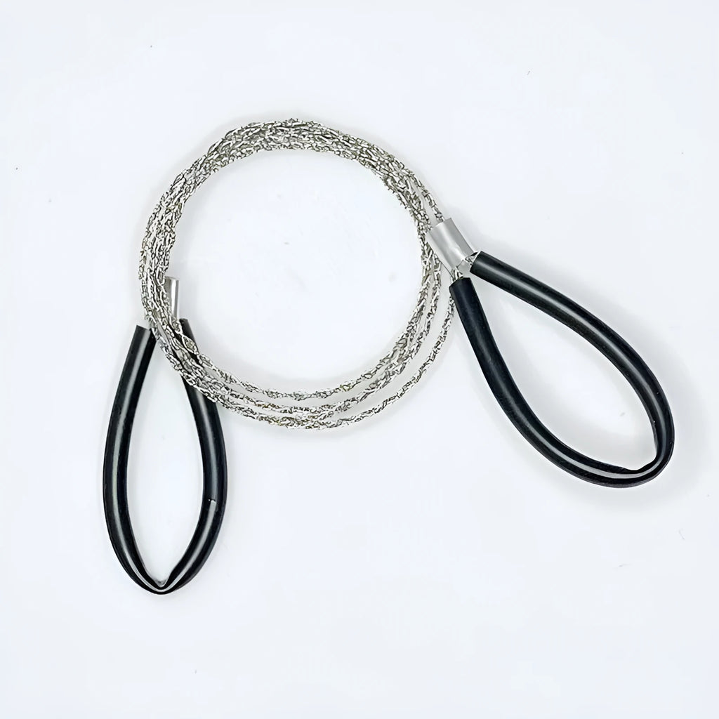 A coiled black or red survival wire saw made of braided stainless steel, shown with a scale indicating its small size.