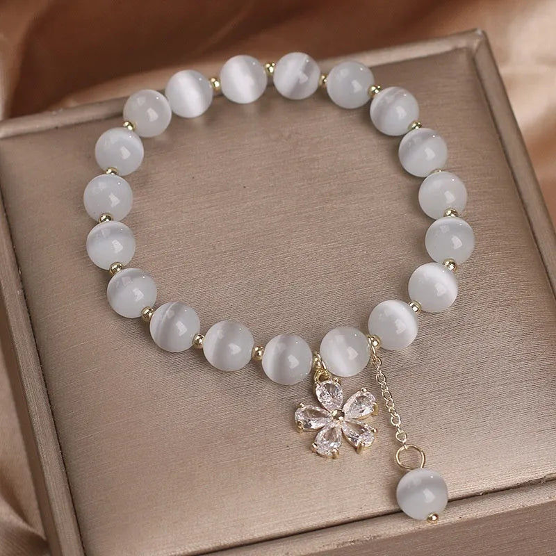 White cat's eye stone women's bracelet with flower tassel and morganite safety buckle pendant.