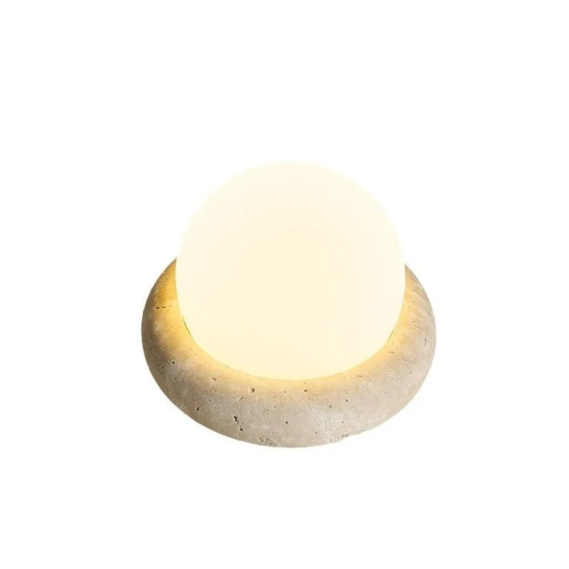 Modern cream-coloured bedside table lamp with wireless remote control on a nightstand.