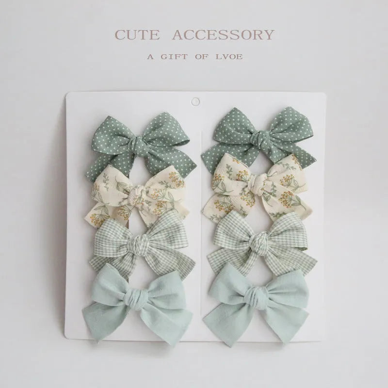 Set of eight fabric dovetail bow hairclips for children in various colours