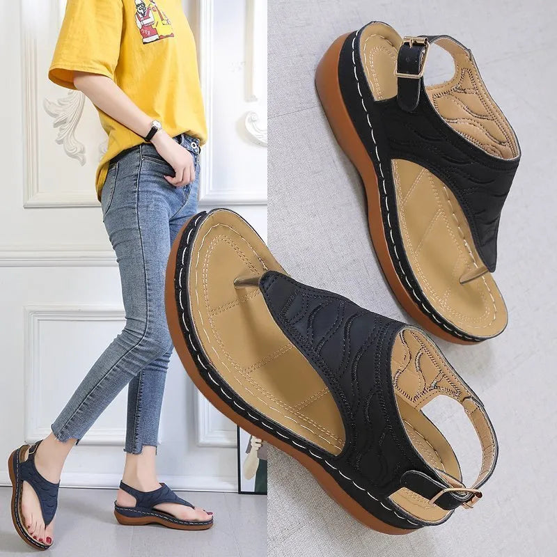 Women's wedge heel flip flop sandals in black with an adjustable back strap and buckle.