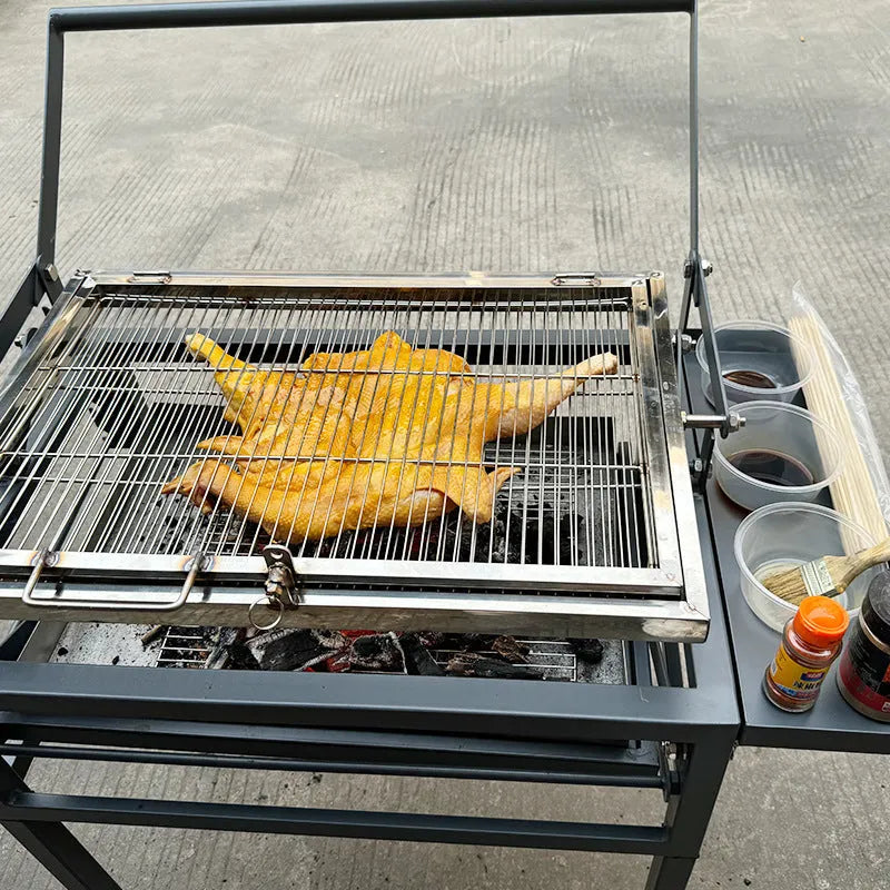 Large foldable charcoal BBQ grill with detachable parts in a garden setting