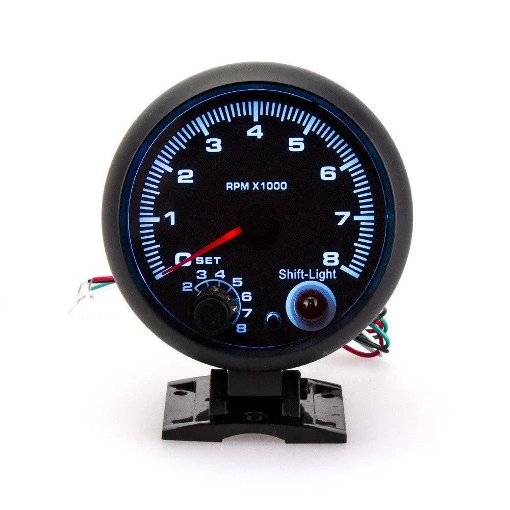 Black automotive tachometer with blue-lit dial showing RPM scale up to 8000