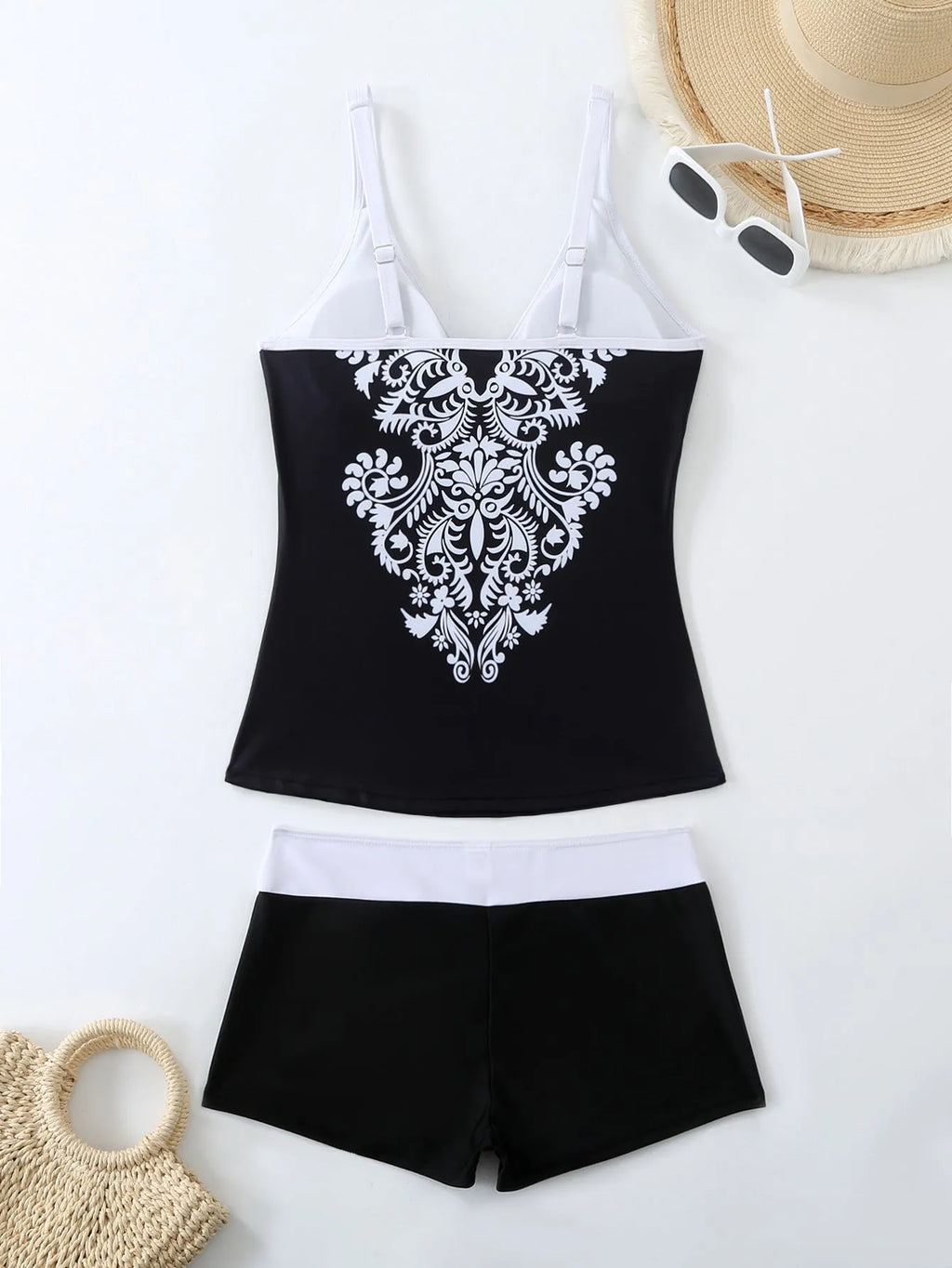 A plus size woman wearing a black two-piece printed swimsuit at the beach.