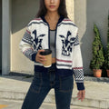 White women's cardigan with contrast stripe pattern, lapel collar, and a full-length front zipper.