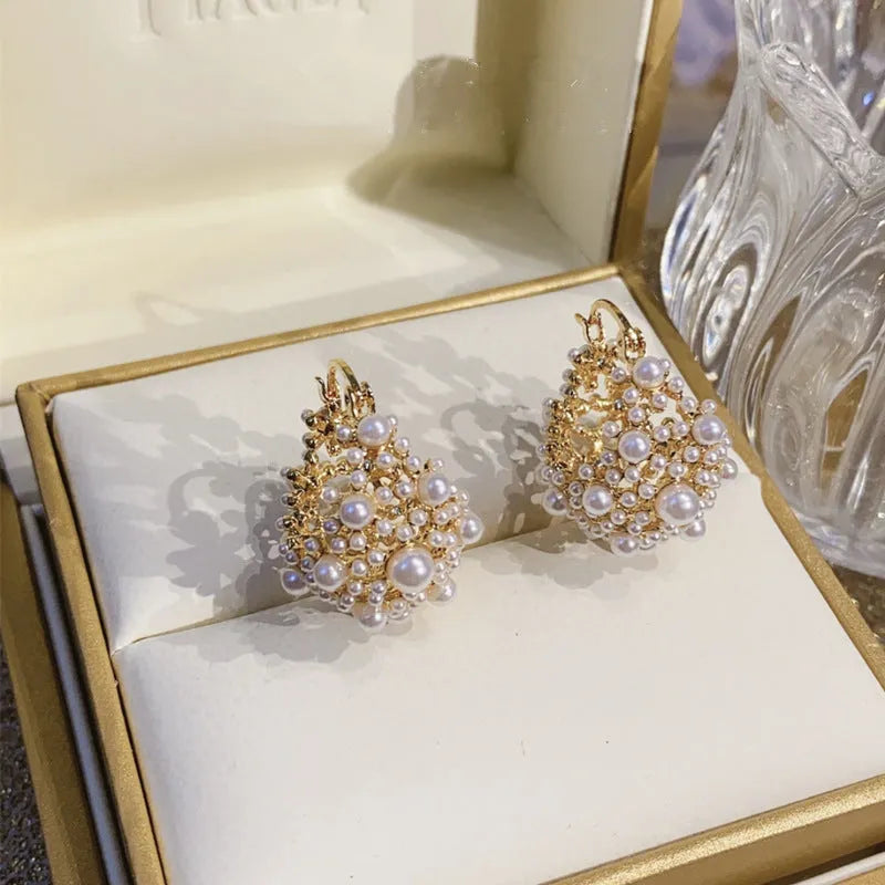 Gold-coloured copper flower basket earrings with pearl inlay and small rice-shaped bead detailing
