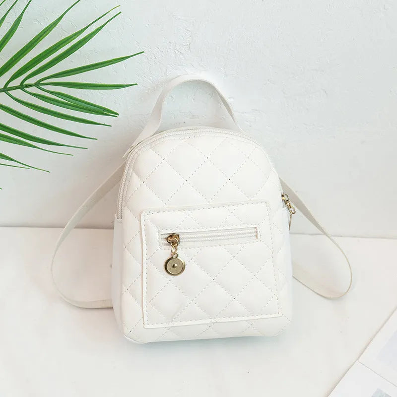 Hard-sided square pink backpack with embroidered detail, shown with soft carry handle and straps.