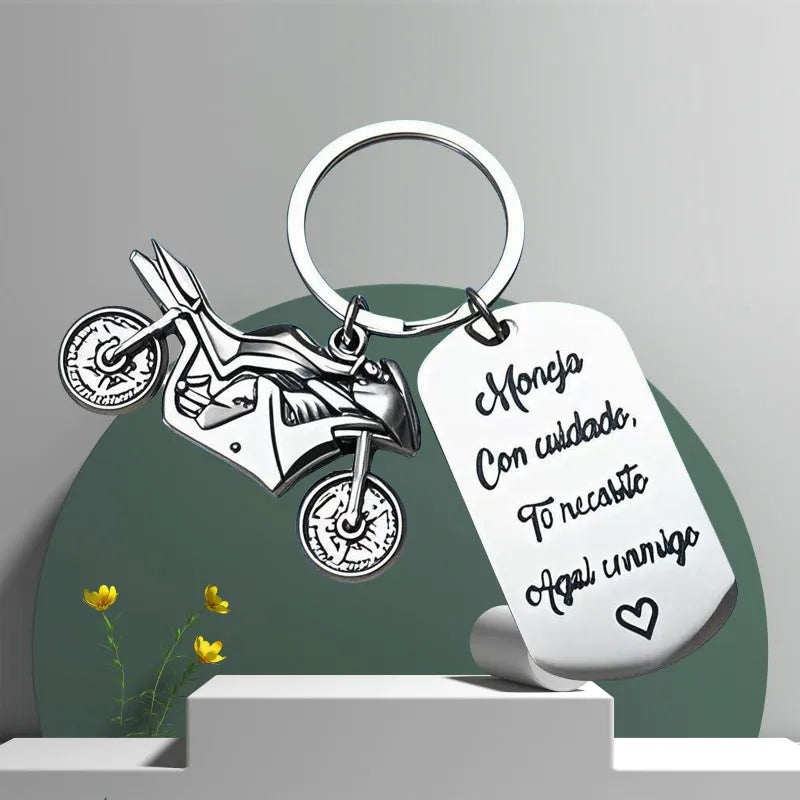 Stainless steel motorcycle key ring with modern design presented with a velvet pouch.