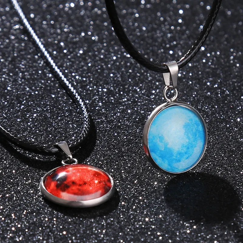 Close-up of a luminous alloy necklace with a blue organic glass constellation pendant on a model.