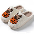 Black and white Halloween slippers with pumpkin pattern, plush upper, and textured rubber sole