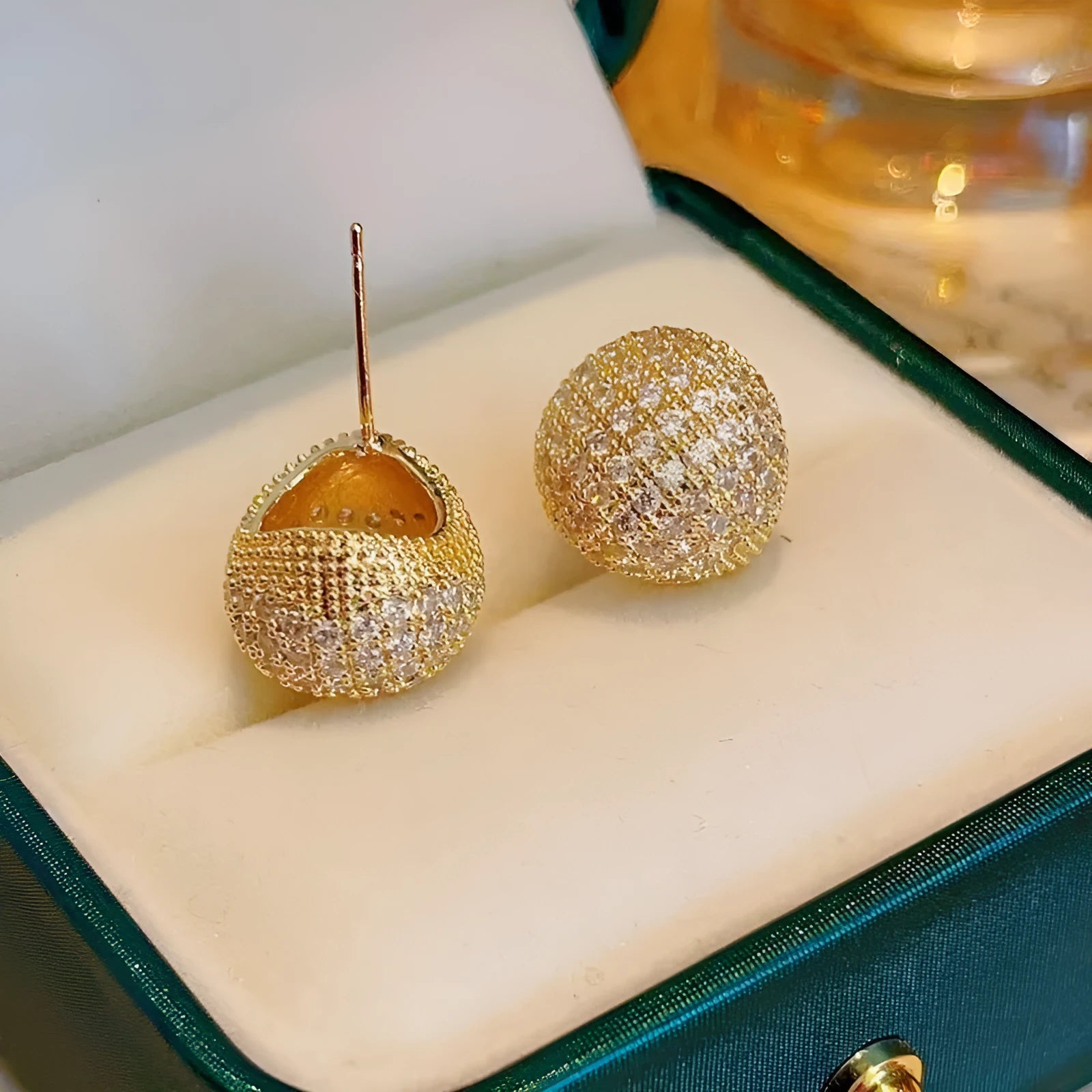 Gold and white geometric drop ear clip earrings with spherical bean design and full diamond flash