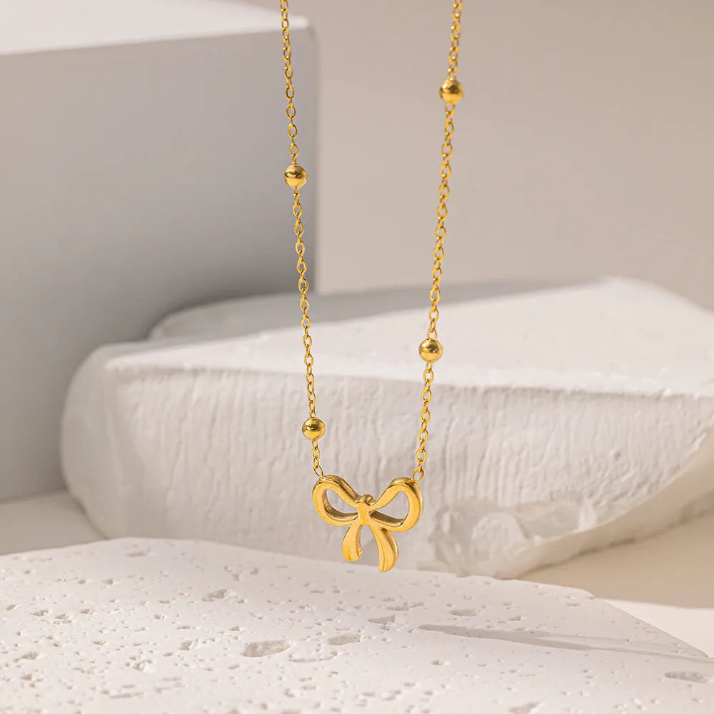 Gold electroplated titanium steel bow necklace with adjustable cross chain