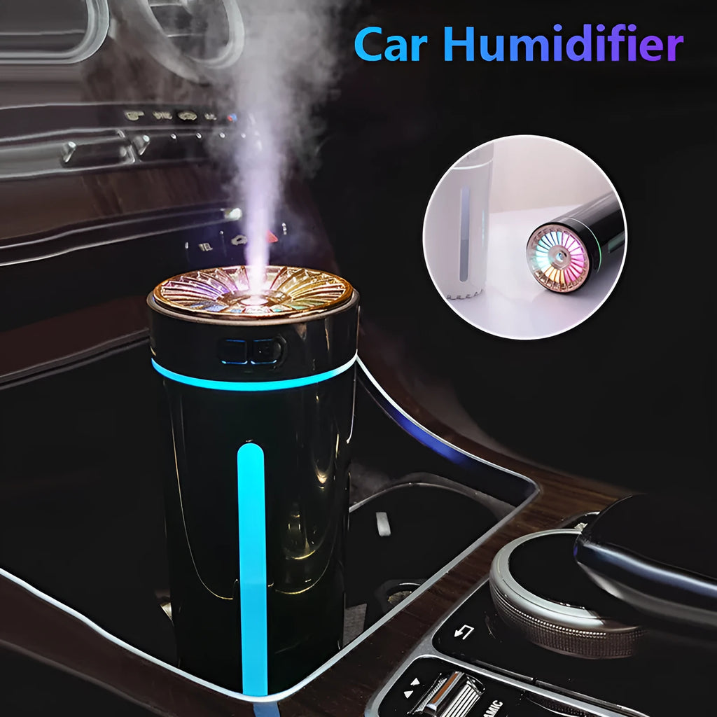 Black portable USB rechargeable car humidifier with colourful lights on a desk next to a cup