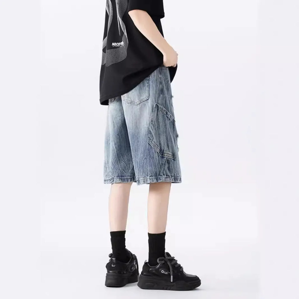 Washed black denim shorts with ripped details and a loose retro fit.