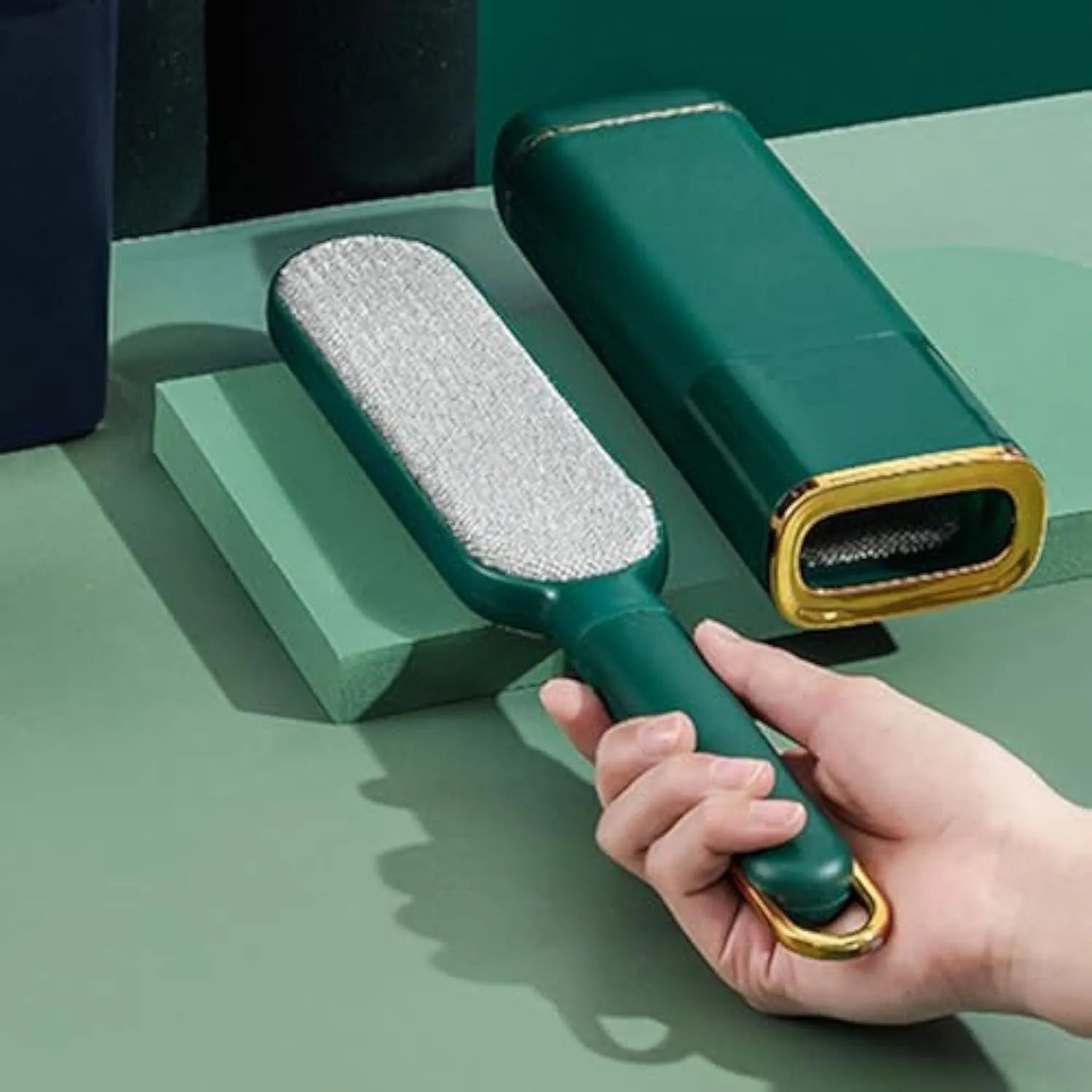Blue green and white double-sided pet hair remover brush with a storage compartment base.