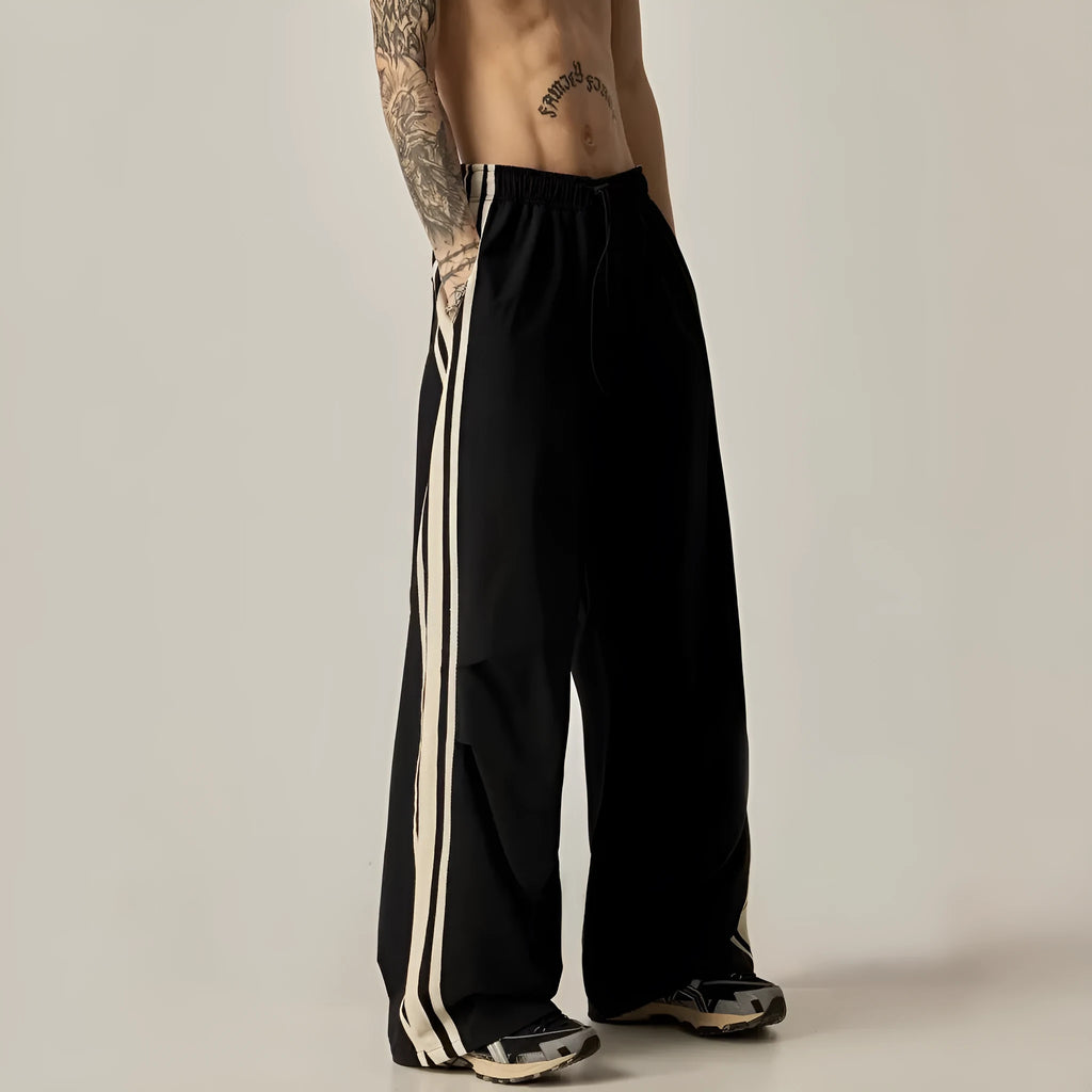 Men's black climbing trousers with high waist and wide straight leg design on hanger