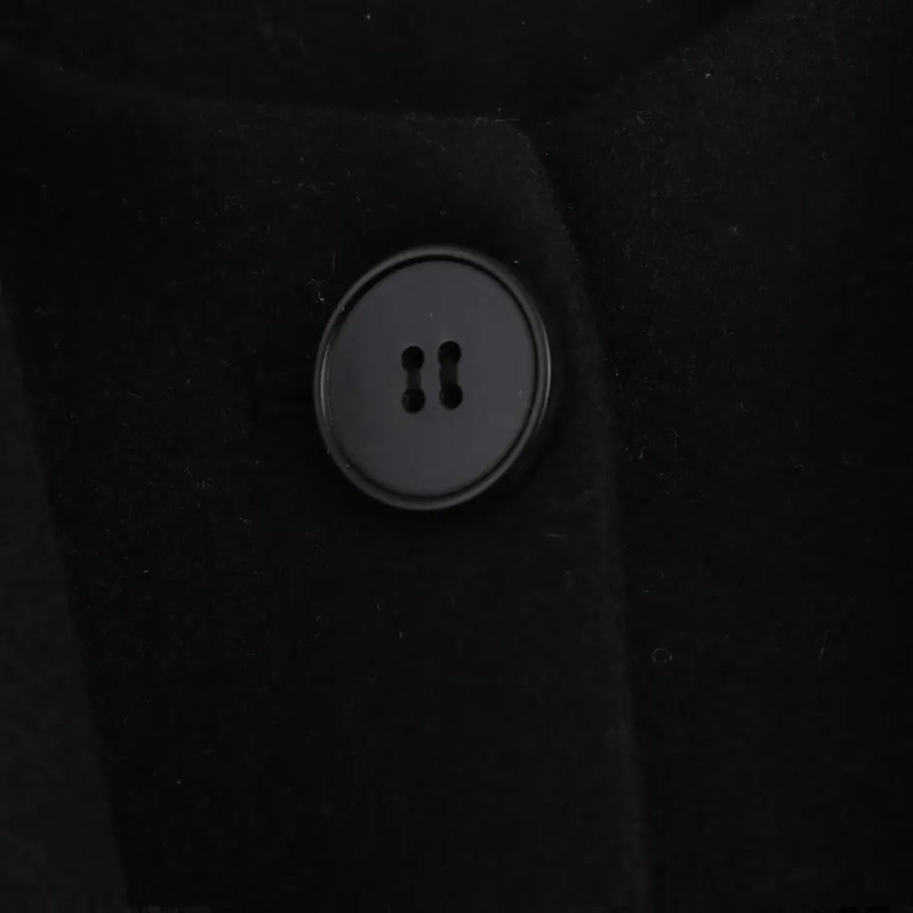 Women's long black coat with a detachable grey artificial fur collar, showing longline silhouette and side pockets.