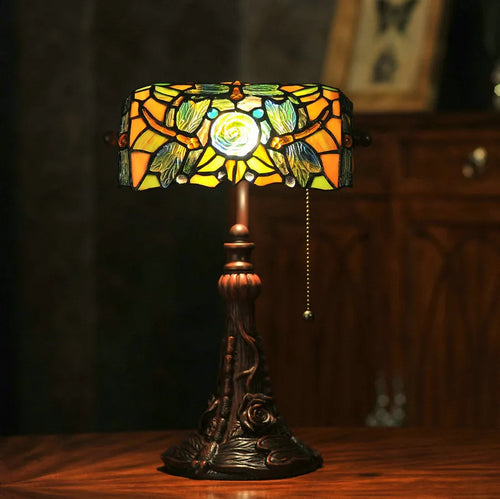 10-inch Tiffany style table lamp with coloured stained glass shade and resin base on a desk.