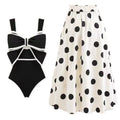 Women's black one-piece swimsuit with a white bow and round skirt on a mannequin, front view.