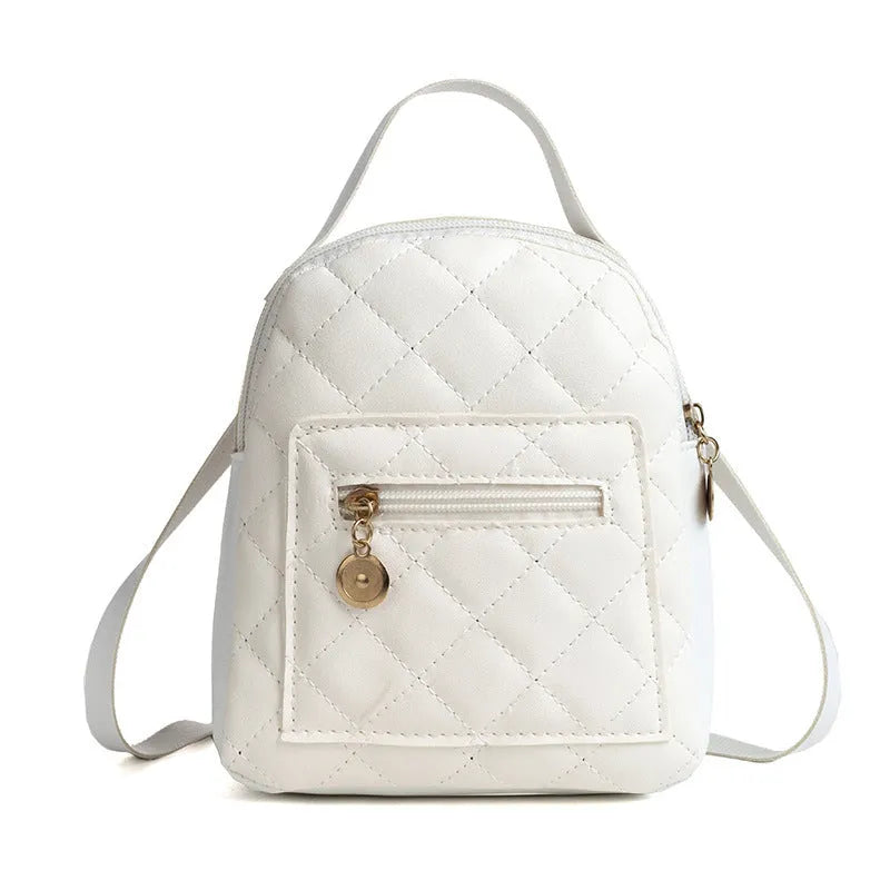 Hard-sided square pink backpack with embroidered detail, shown with soft carry handle and straps.