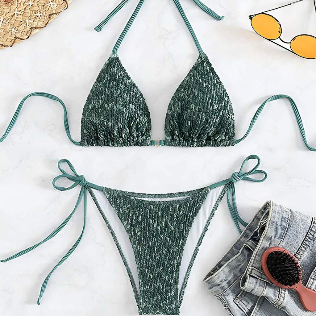 Green women's backless halter strap bikini set with matching shorts on a mannequin.