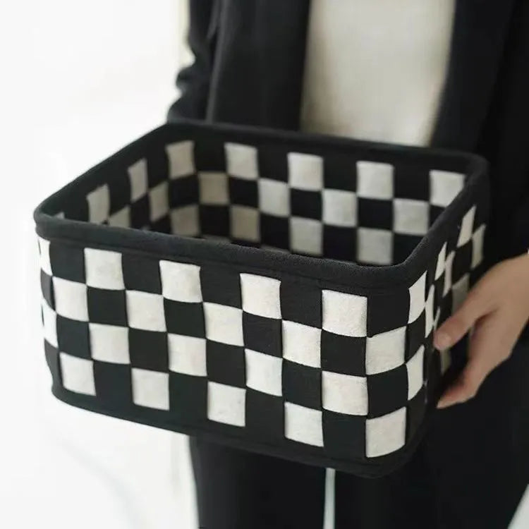 Grey and black checkerboard woven felt folding storage box with collapsible sides.
