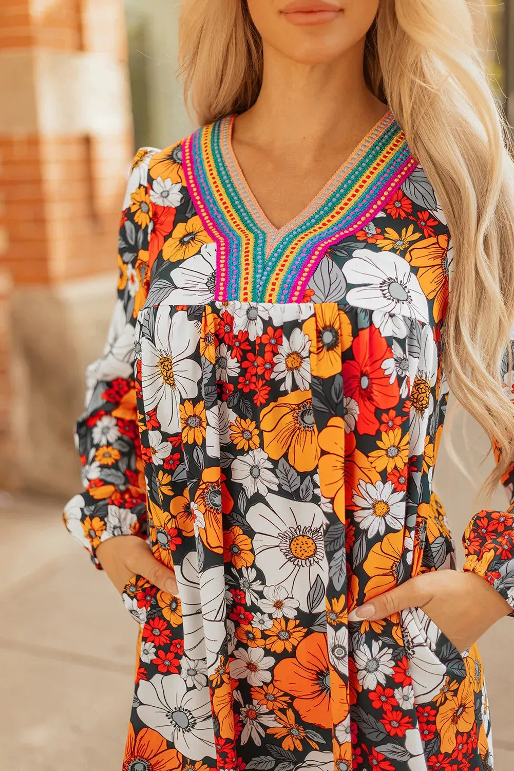 Orange floral print mini dress with striped lace detailing, V-neck, and long sleeves.