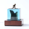 Clear epoxy resin ornament with a shark surfing scene inside, shown next to a 5cm and 8cm size option.