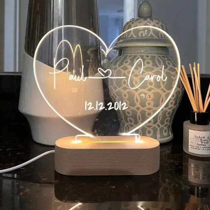 Custom clear acrylic night light with engraved names, lit by an LED base.
