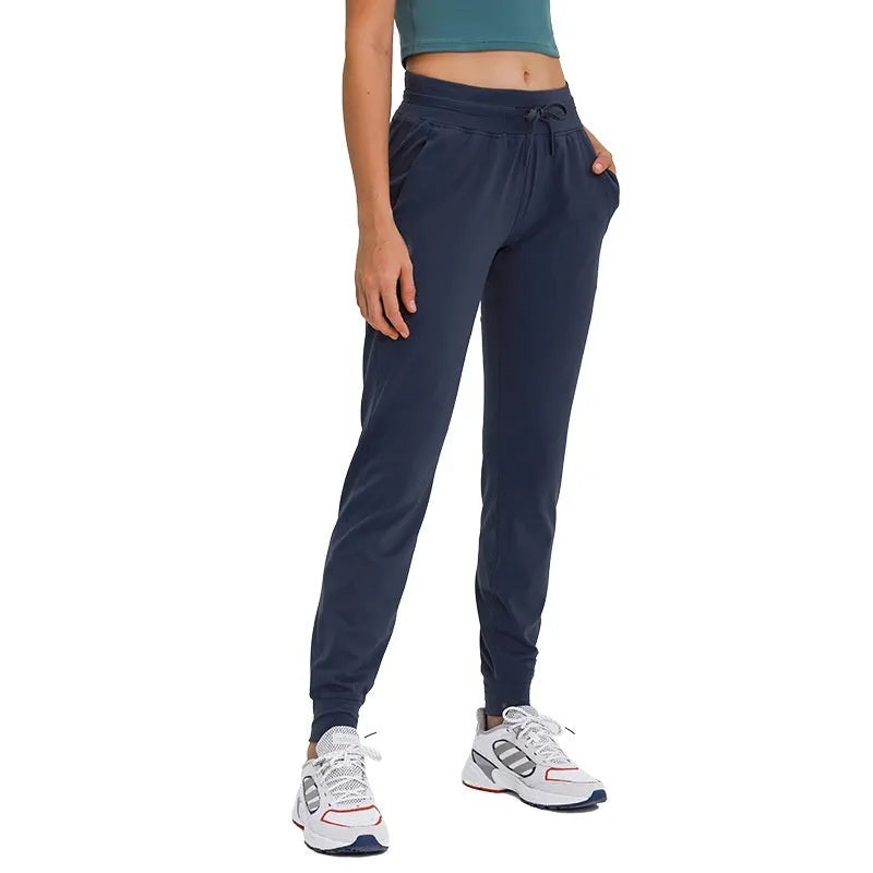 Woman wearing high-waisted blue yoga pants with a drawstring waistband for fitness.