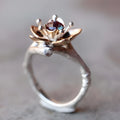 Silver two-tone women's floral ring with a simple geometric shape on a neutral background.
