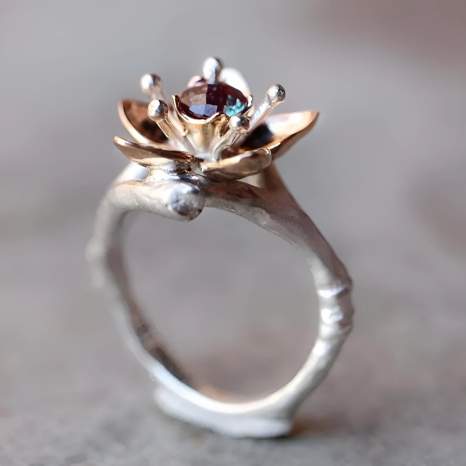 Silver two-tone women's floral ring with a simple geometric shape on a neutral background.