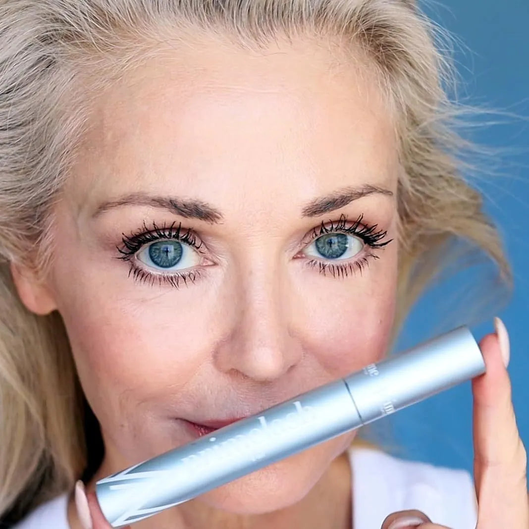 Eye black make-up tool with a small brush head and integrated comb for eyelash application and grooming.