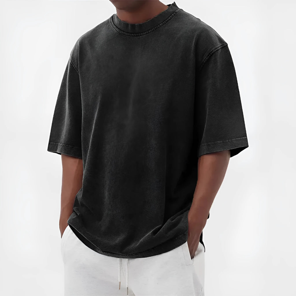 Man wearing a loose-fit stone washed solid colour t-shirt in a casual setting.