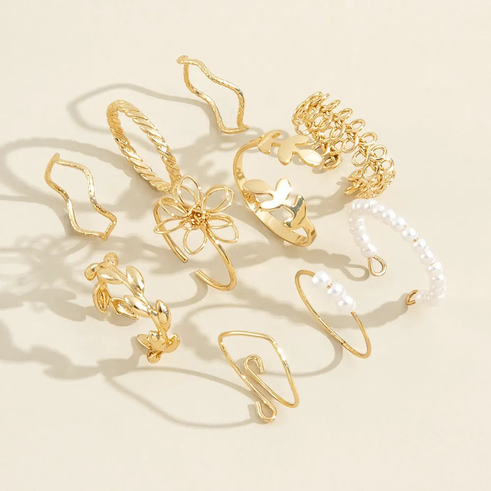 Gold tone openwork flower ring with intricate floral pattern design and glossy finish