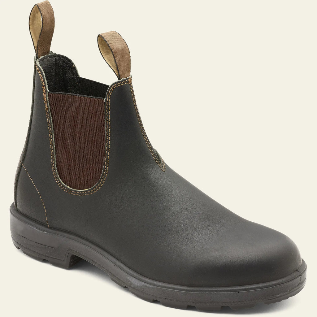 Vintage brown unisex Chelsea ankle boots with car suture stitching and a low heel on a wooden floor.