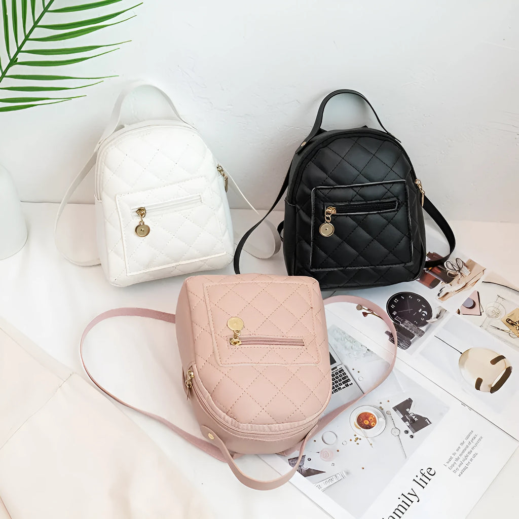 Hard-sided square pink backpack with embroidered detail, shown with soft carry handle and straps.