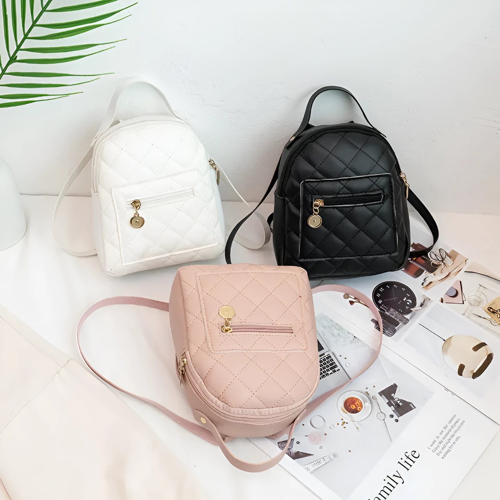 Hard-sided square pink backpack with embroidered detail, shown with soft carry handle and straps.