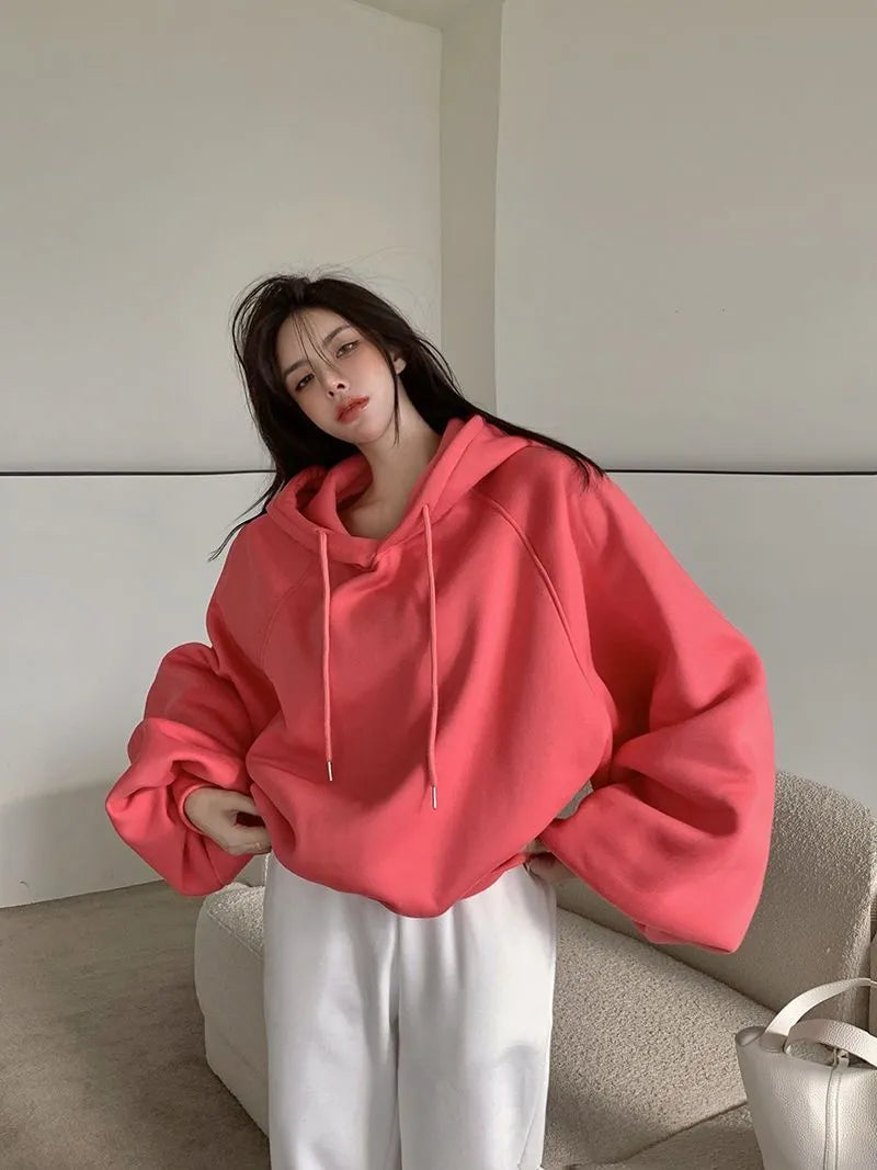 Watermelon red women's sleeveless hooded sweater made from mulberry silk fabric on a hanger.