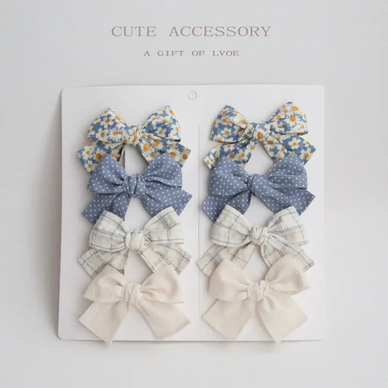 Set of eight fabric dovetail bow hairclips for children in various colours
