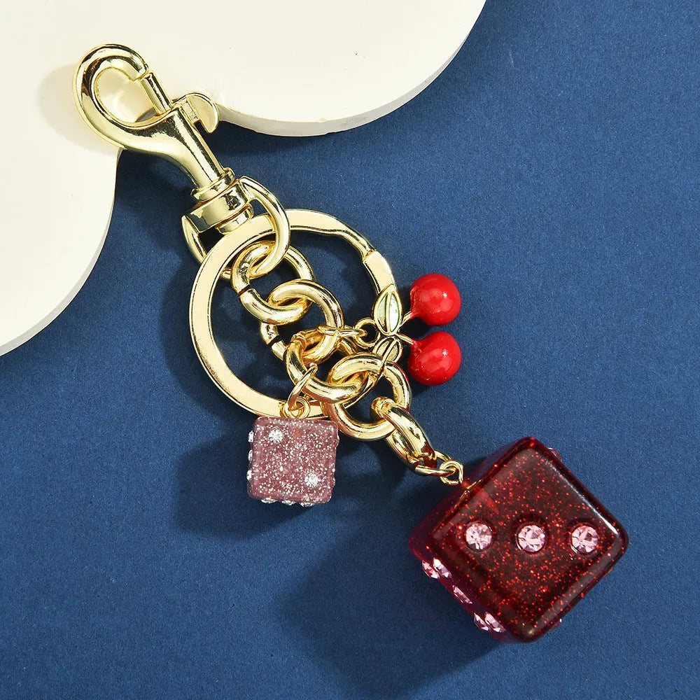 Square metal keychain pendant with a vintage cherry two-colour dice design.
