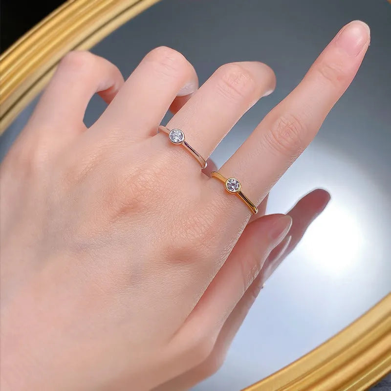 Minimalist crown shape silver ring electroplated in gold or platinum colour on a plain background.