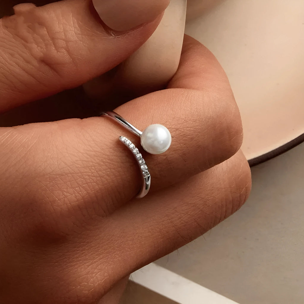 Adjustable sterling silver ring for women with a central shell pearl on an open-loop band.